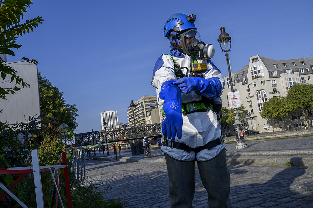 Opérateur se préparant à intervenir dans un réseau d’assainissement : il porte notamment un contrôleur d'atmosphère multigaz, un masque autosauveteur et un harnais de sécurité Opérateur se préparant à intervenir dans un réseau d’assainissement : il porte notamment un contrôleur d'atmosphère multigaz, un masque autosauveteur et un harnais de sécurité
